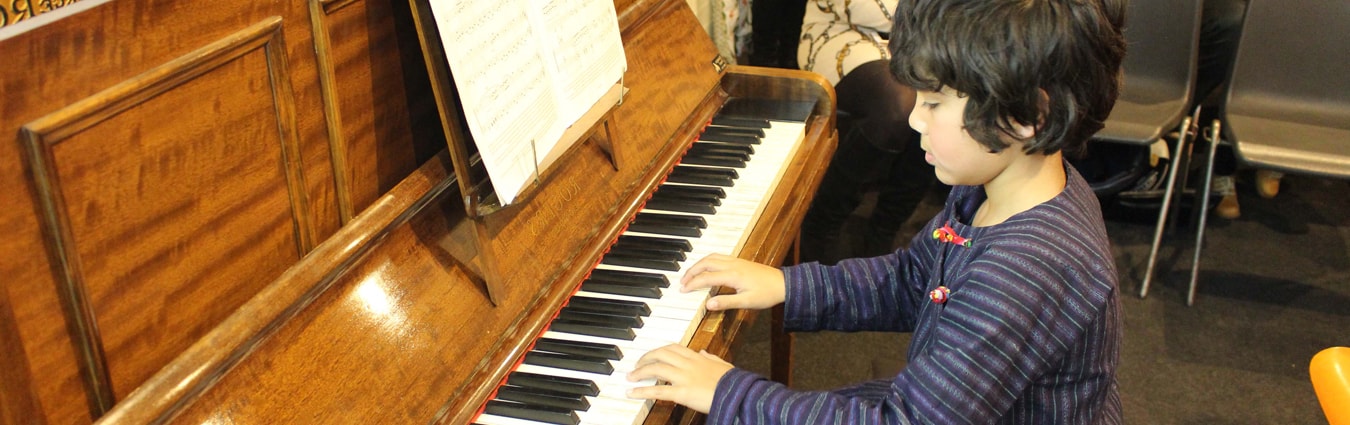 Child playing piano at Stringnote Academy