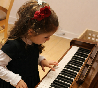 Young child exploring piano keys